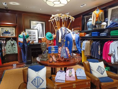Şık Ralph Lauren iç dekorasyonu, erkek giyim, polo tişörtler, deri aksanlar, ve sıcak ahşap panelli bir butikte görsel pazarlama. Londra, İngiltere, 8 Haziran 2024