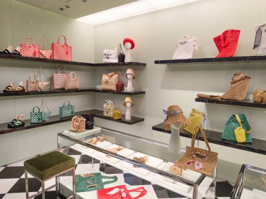 Zarif raflarda renkli tasarımcı çantaları ve aksesuarları bulunan lüks Prada butiği. Londra, İngiltere, 8 Haziran 2024