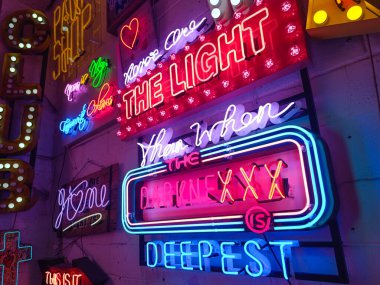 Renkli neon tabelalar ve ampul ışıklı afiş sanatı canlı bir retro sahne yaratıyor. Londra, İngiltere, 23 Haziran 2024