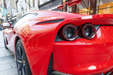 Şehirde kırmızı bir Ferrari süper arabasının arka tarafında, çift farları, parlak boyaları, egzozları ve pürüzsüz aerodinamik çizgileri vurguluyorlar. Londra, İngiltere, 28 Ağustos 2023