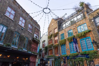 Covent Garden, Londra 'daki Neals Yard' ın renkli avlu manzarası, canlı cepheleri, tuğla binaları, sicim ışıkları, yeşillik ve canlı şehir atmosferiyle. Londra, İngiltere, 2 Eylül 2023