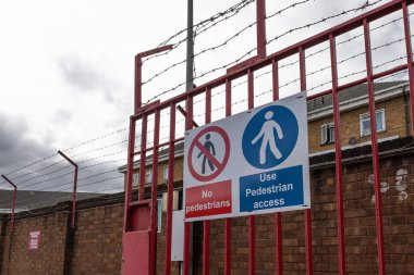 Endüstriyel alandaki kırmızı metal güvenlik kapısını kapatın, dikenli teller yerleştirin ve giriş yapmayın..