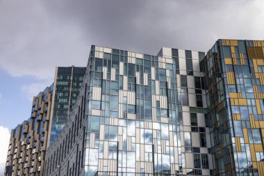 Şehir manzarasındaki ofis binalarının modern cam cephesinde soyut yansımalar.