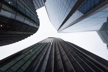 Yüksek katlı ticari binalara bakıyorum. Şehir silueti perspektifi geometrik çizgiler ve parlak bir gökyüzüne karşı yapı.