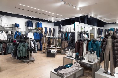 Giysi rafları ve mankenlerle dolu modern bir giyim mağazası. Londra, İngiltere, 24 Aralık 2023