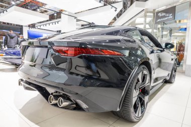 Bir otomobil fuarında sergilenen 75 baskılı siyah bir Jaguar F-Type Coupe 'nin arka görüntüsü. Gösterişli tasarımı ve dört egzoz boruları olan lüks İngiliz spor arabası. Londra, İngiltere, 24 Aralık 2023
