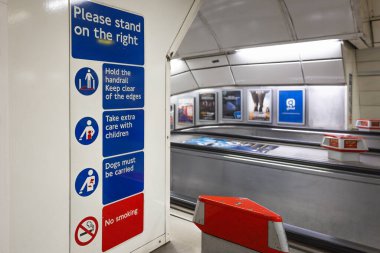 Bir Londra metro istasyonunun içinde güvenlik levhası olan yolculara sağda durmalarını ve yürüyen merdivenin yanında tırabzanları tutmalarını söyleyen bir yer. Londra, İngiltere, 31 Aralık 2023