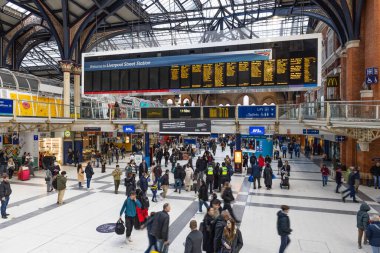 Londra 'daki Liverpool Caddesi İstasyonu' ndaki yoğun binanın geniş açılı görüntüsü yoğun saatlerde büyük çıkış panosunu kontrol eden banliyö personeliyle dolu. Londra, İngiltere, 11 Şubat 2024