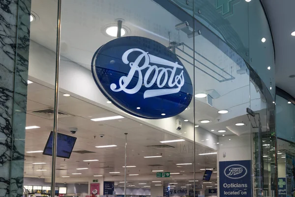 İkonik mavi logo işareti olan bir Boots eczane girişinin dış görünüşü. İngiltere 'nin ana caddesinde popüler bir sağlık ve güzellik perakendecisi. Londra, İngiltere, 17 Şubat 2024