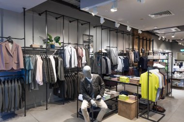 Modern bir erkek giyim mağazasının arka planı. İçi takım elbise, gömlek ve mankenlerle dolu. Londra, İngiltere, 17 Şubat 2024