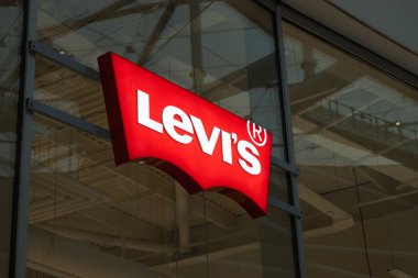 Cam bir vitrinin üzerine asılmış kırmızı Levis logosunu kapat. Perakende satış merkezinde ünlü kot markası tabelası. Londra, İngiltere, 17 Şubat 2024