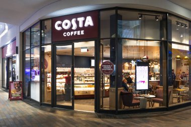 Modern bir alışveriş merkezindeki Costa Kafe 'nin dışında. Popüler İngiliz kahve zincirinde cam ön cephe, kestane rengi tabela ve görünür iç koltuklar yer almaktadır. Londra, İngiltere, 17 Şubat 2024