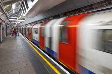 Londra metro istasyonuna varan hızlı bir metro treninin dinamik hareket bulanıklığı. Londra, İngiltere, 3 Mart 2024