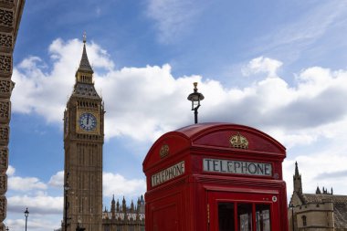Klasik Londra kırmızı telefon kulübesi Big Ben 'in yanında duruyor. Londra, İngiltere, 16 Mart 2024