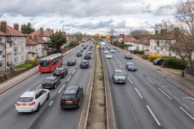 Banliyö evleriyle dolu şehir otobanındaki sabit trafiğin manzarası, günlük banliyö trafiğini, ulaşım altyapısını ve şehir hareketliliğini kaydediyor. Londra, İngiltere, 17 Mart 2024