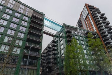 Şehirdeki lüks apartmanlar arasında yerden yüksekte asılı yenilikçi Sky Pool köprüsünün düşük açılı görüntüsü. Londra, İngiltere, 6 Nisan 2024