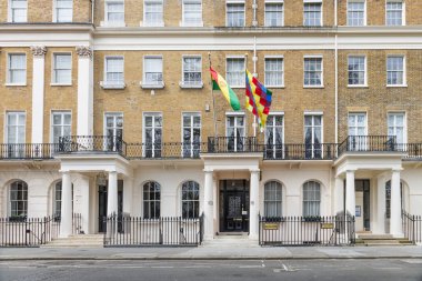Londra 'daki Bolivya diplomatik misyonunun ön cephesinde sarı tuğla duvarlar, beyaz sütunlar ve girişte resmi bayraklar asılı. Londra, İngiltere, 6 Nisan 2024