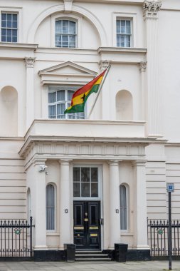 Londra 'daki Gana Yüksek Komisyonu binasında beyaz bir neoklasik cephe ve bir balkondan belirgin bir şekilde dalgalanan ulusal bayrak yer alıyor. Londra, İngiltere, 6 Nisan 2024