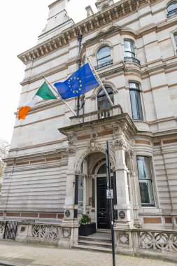 İrlanda ve Avrupa Birliği bayrakları Londra 'daki İrlanda Büyükelçiliği binasının taş cephesinin üzerinde dalgalanıyor. Londra, İngiltere, 6 Nisan 2024
