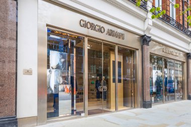 Giorgio Armani 'nin lüks butik girişinin geniş bir görüntüsü. Cilalı metalik çerçeveler ve şehir caddesinde cam pencereler var. Londra, İngiltere, 6 Nisan 2024