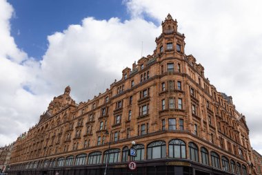 Londra 'daki Harrods binasının terracotta cephesinin ve taretlerinin geniş açılı görüntüsü bulutlu bir gökyüzünün altında. Londra, İngiltere, 7 Nisan 2024