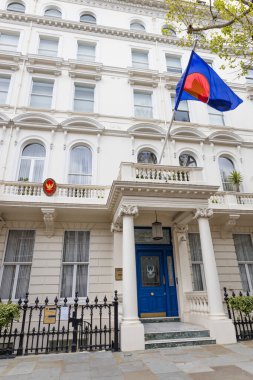 Londra 'daki Tayland Kraliyet Elçiliği' nin dış cephesinde beyaz bir Viktorya dönemi cephesi, sallanan bir ulusal bayrak ve mavi bir giriş kapısının üzerinde Garuda amblemi bulunur. Londra, İngiltere, 7 Nisan 2024