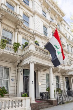 Aydınlık bir günde üç renkli ulusal bayrak ile süslenmiş, Londra 'daki Irak hükümet diplomatik bürosunun belirgin beyaz cephesine bakıyorum. Londra, İngiltere, 7 Nisan 2024