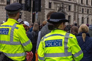 Yüksek görüşlü sarı ceketli Metropolitan Polis memurları Londra 'da kalabalığın arasında duruyor, halk toplantısı sırasında ya da protesto sırasında düzeni sağlıyorlar..