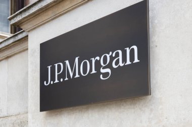 Beyaz J.P. Morgan logosu olan siyah bir plaket şirket binasının dışındaki açık renkli taştan bir duvara asılmış. Londra, İngiltere, 5 Mayıs 2024