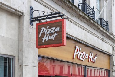 Şehir merkezinde bir tuğla bina cephesindeki Pizza Hut tabelasını kapat. Londra, İngiltere, 5 Mayıs 2024