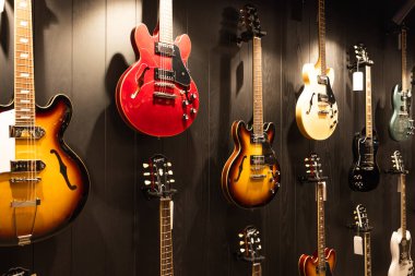 Gibson Garaj Santrali 'nin karanlık desenli duvarında ikonik elektro gitarların profesyonel gösterisi. Londra, İngiltere, 11 Mayıs 2024