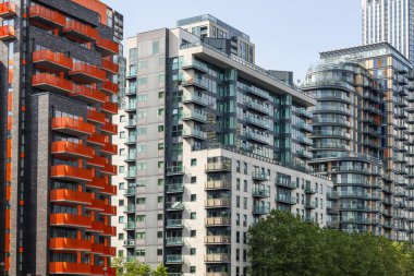 Kalabalık bir metropol bölgesinde karışık malzeme ve balkon tasarımlarının yer aldığı çağdaş yüksek binaların manzarası.