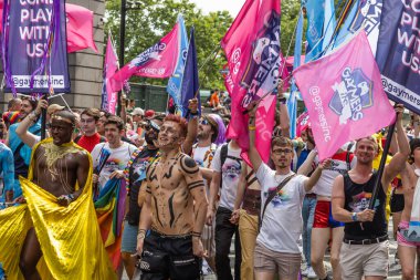 Bir grup farklı insan Londra Onur Yürüyüşü sırasında eşitlik ve aşkı şehir merkezinde renkli bayraklar ve kostümlerle kutluyor. Londra, İngiltere, 29 Haziran 2024