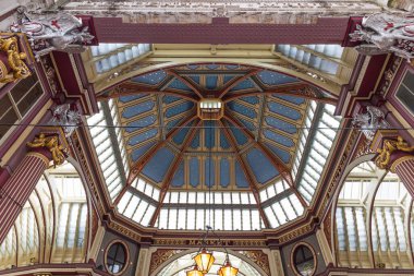 Londra 'daki tarihi Viktorya dönemi Leadenhall Pazarı' nın göz kamaştırıcı boyalı tavan ve cam çatısına bakın..