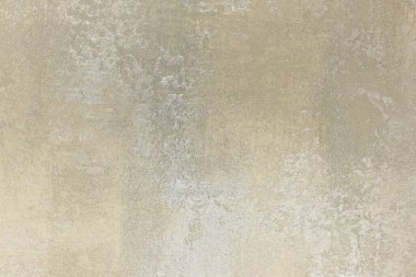 Soluk, eski görünümlü, bej ve gri renklerde pürüzsüz ama yumuşak desenli bir zemin oluşturan bir duvarı kapatın..