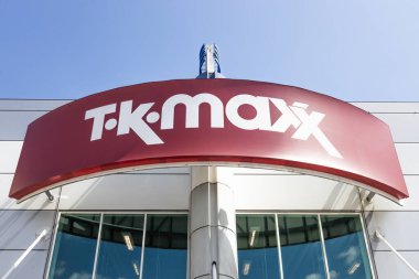 TK Maxx mağaza tabelası, açık mavi gökyüzü altında modern bir perakende mağazasının girişinde belirgin bir şekilde sergileniyordu. Londra, İngiltere, 28 Temmuz 2024