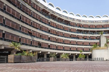 Londra, Barbican Konutları 'nda, ahşap panjurlar ve ekicilerle beton balkonların bulunduğu eğri büğrü bir barbar yerleşim yeri..