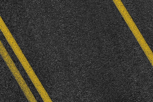 Level asphalted road with a dividing yellow stripes. The texture of the tarmac, top view. — Stock Photo, Image