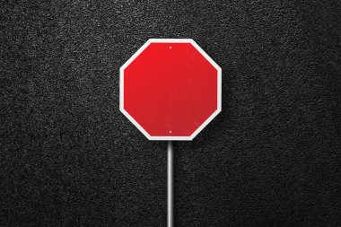 Red road sign on a background of asphalt. The texture of the tarmac, top view. clipart