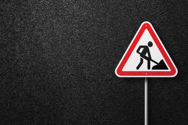 Asfalt bir arka plan üzerinde bir işçi resmi ile üçgen şekil işareti. Yol işleri. Asfalt dokusu, üst görünüm.
