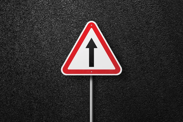 Road sign triangular shape with pointer on a background of asphalt. The texture of the tarmac, top view. — Stock Photo, Image