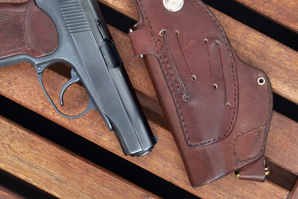 Пистолет и кобура Макарова лежат на деревянных досках . — стоковое фото