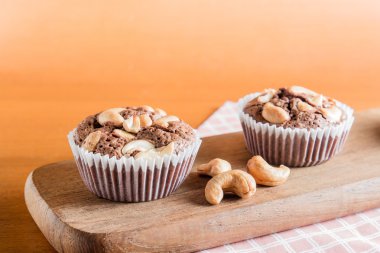 Fincan çikolatalı kek kek ile kaşu fındık üzerinde ahşap Backgr