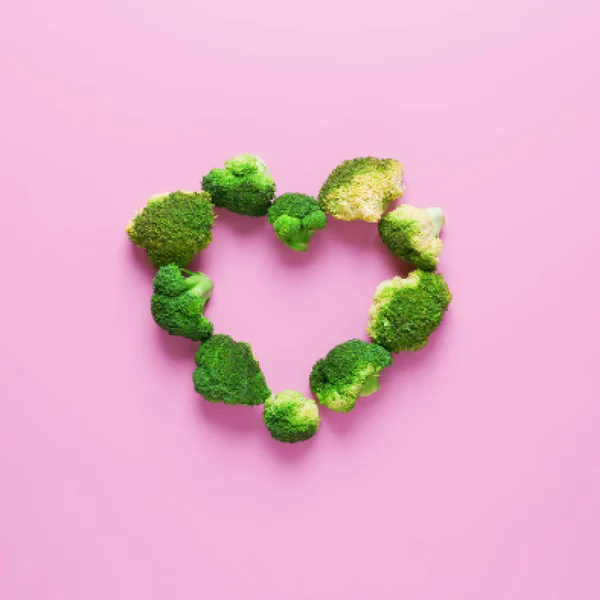 Heart shape made from fresh raw broccoli on pink background — Stock Photo, Image