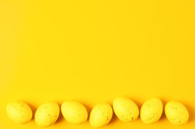 Sarı arka planda Paskalya sarısı yumurtalar. Düz yat, boşluğu kopyala.