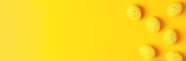 Sarı arka planda Paskalya sarısı yumurtalar. Düz yat, boşluğu kopyala.