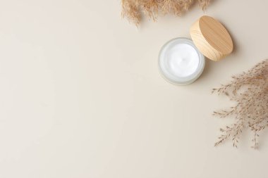 Beyaz arka planda otla kaplı bir kavanoz kozmetik kremi. Düz yat, boşluğu kopyala