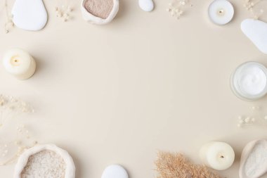 Cilt bakım ürünleri, taşlar, mumlar ve pastel bej çiçekli kaplıca. Düz yat, boşluğu kopyala