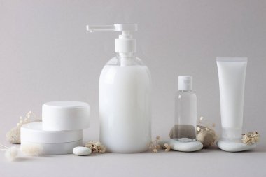 Kozmetik cilt bakım ürünleri içeren kompozisyon, gri üzerine taşlar ve çiçekler. Kapat, boşluğu kopyala