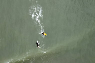 Dalgalı denizlerde sörfçü
